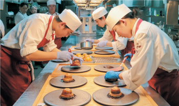 料理を盛り付ける料理人たち