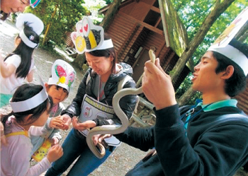 ヘビと触れ合う子どもたち