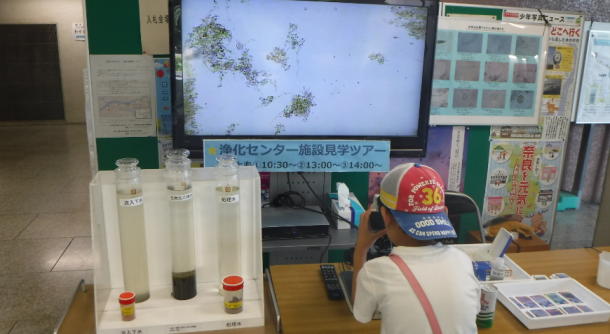 顕微鏡で微生物を見ています