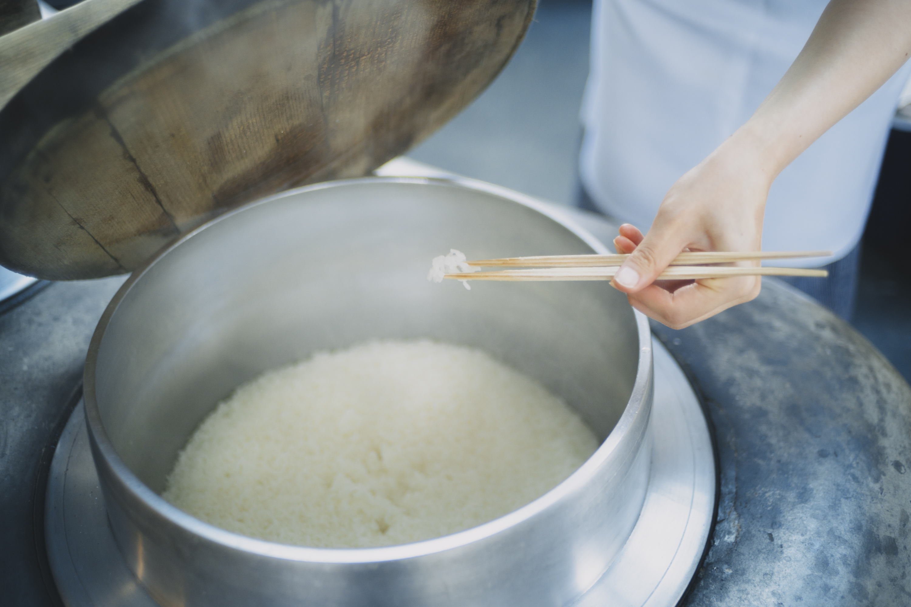 かまどで炊き上がったご飯を箸で確かめる様子